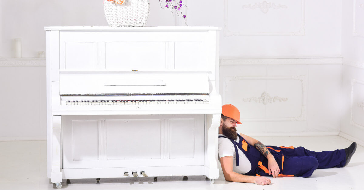 man resting while moving a piano